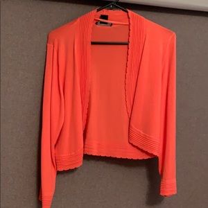 Salmon colored cardigan.